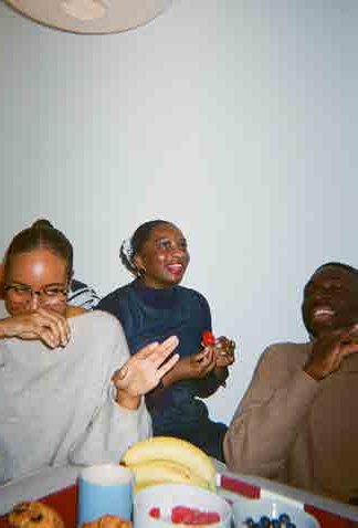 Three students laughing over dinner